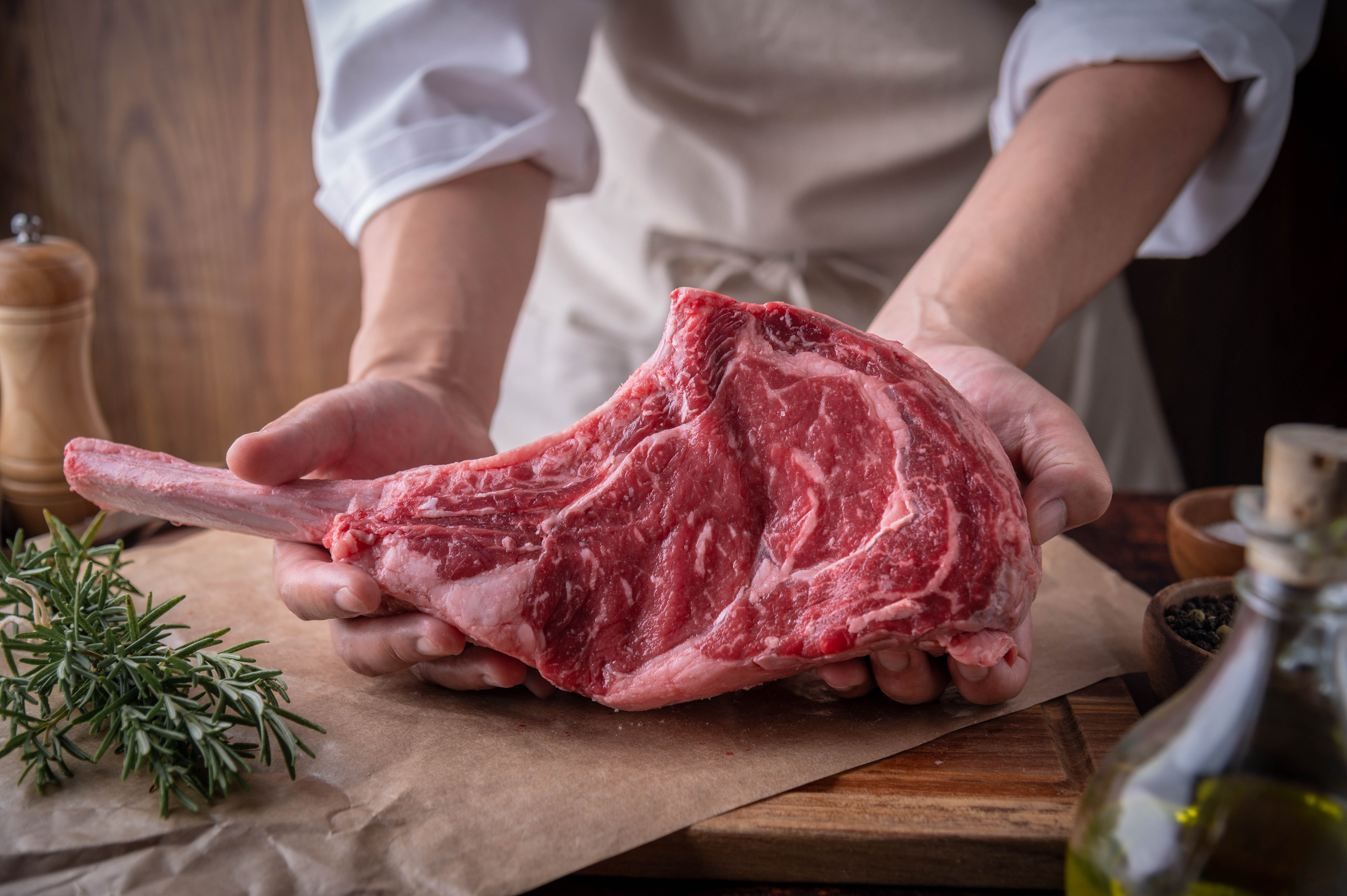 Butcher,Serving,Fresh,Tomahawk,Steak,Meat,To,Customer